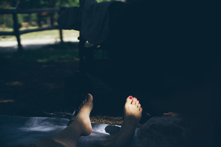 woman on blanket with toes in the sun