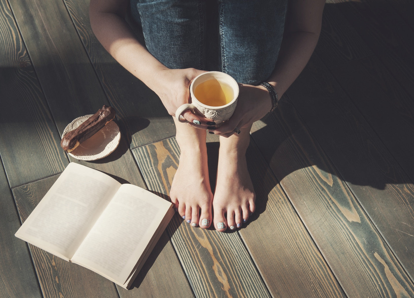 Women with green tea in hand and book
