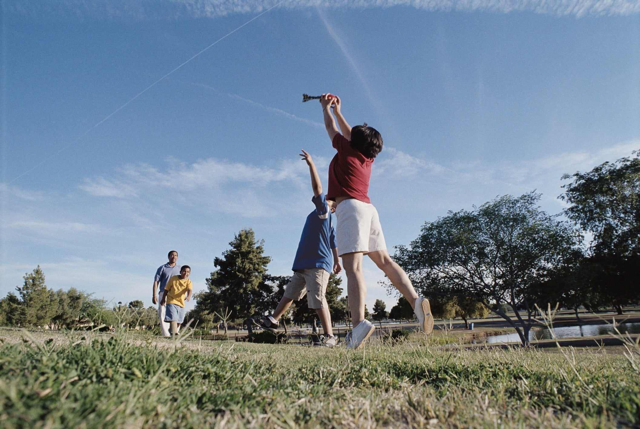 father playing with three sons at the field
