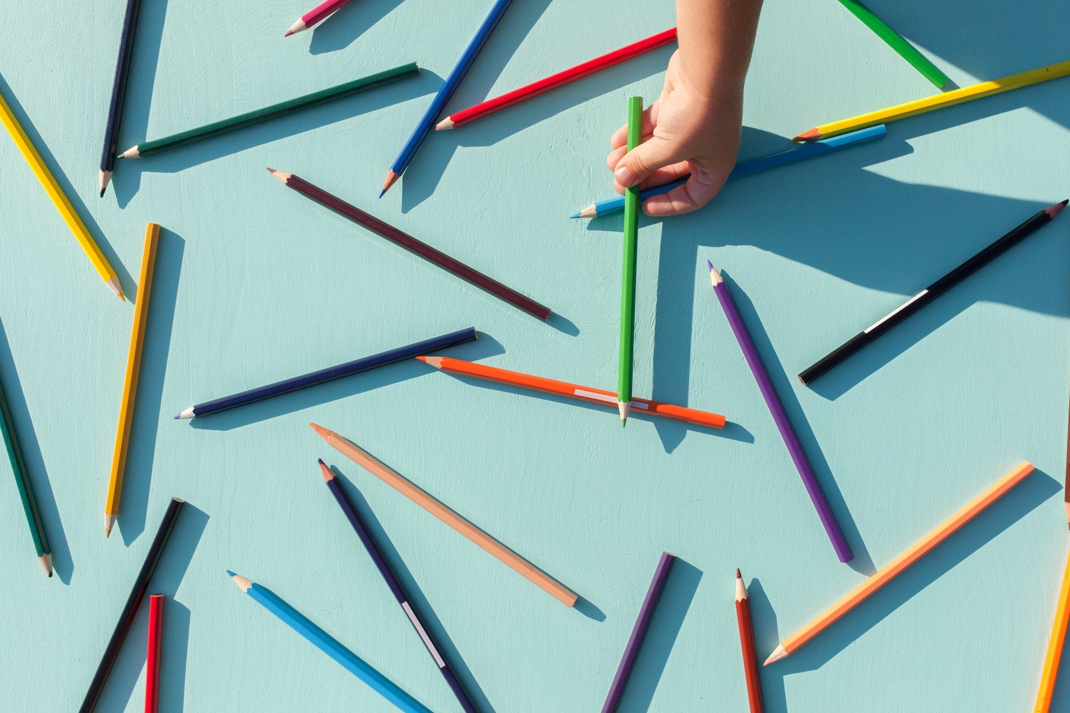 colored pencils scattered on blue background