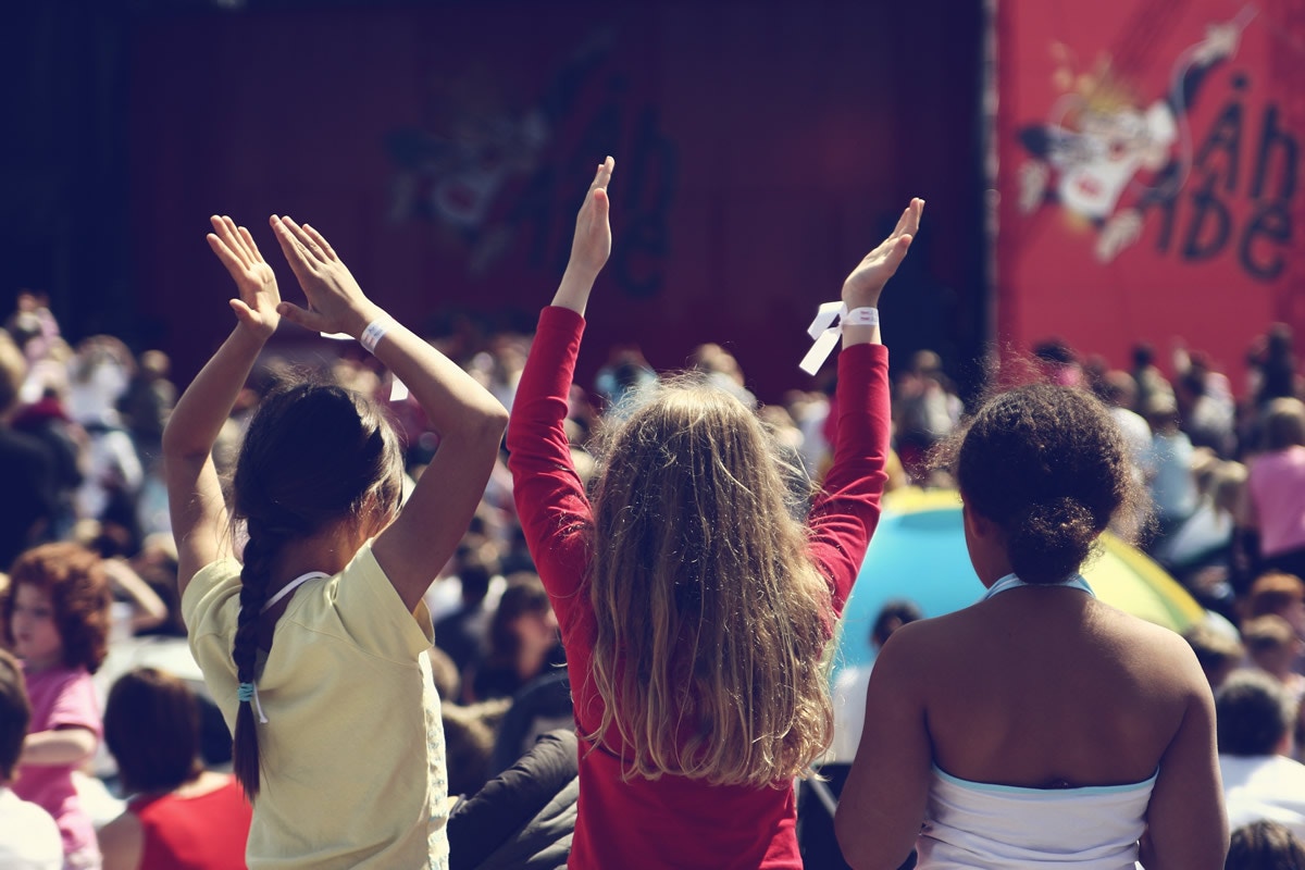 three young girls holding their hands up