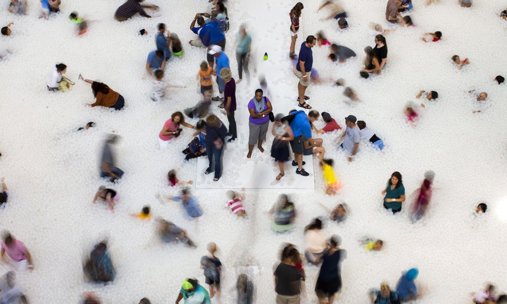 many people playing with their kids in white balls