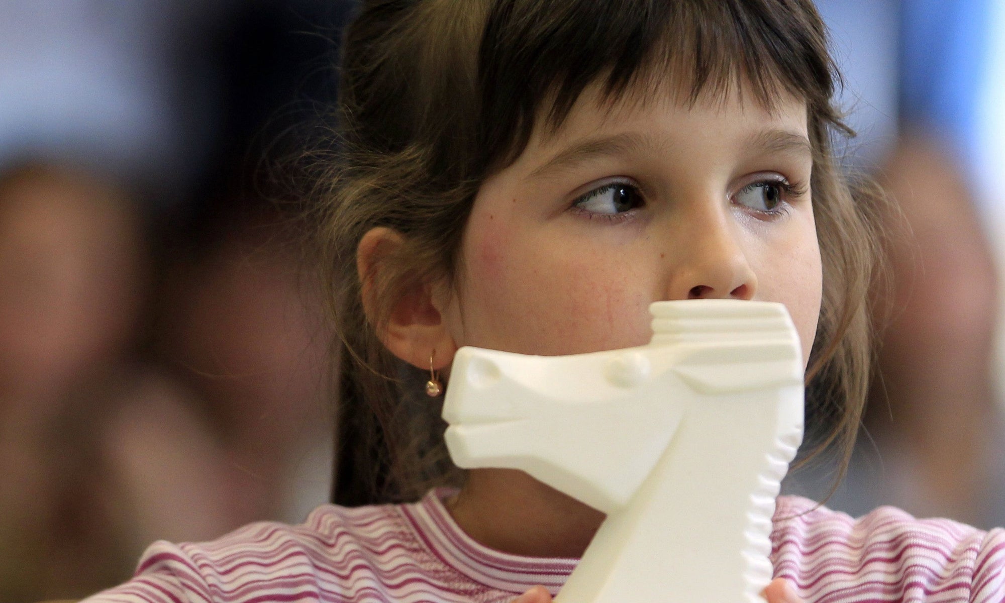 young girl holding her toy horse