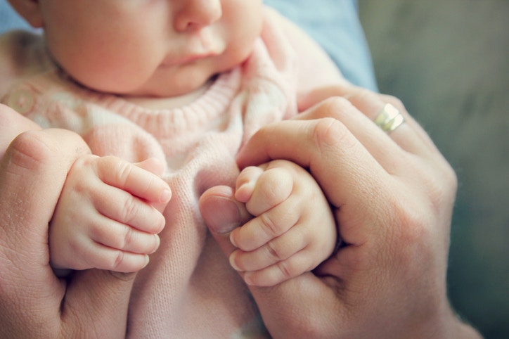 father holding cute little baby hands