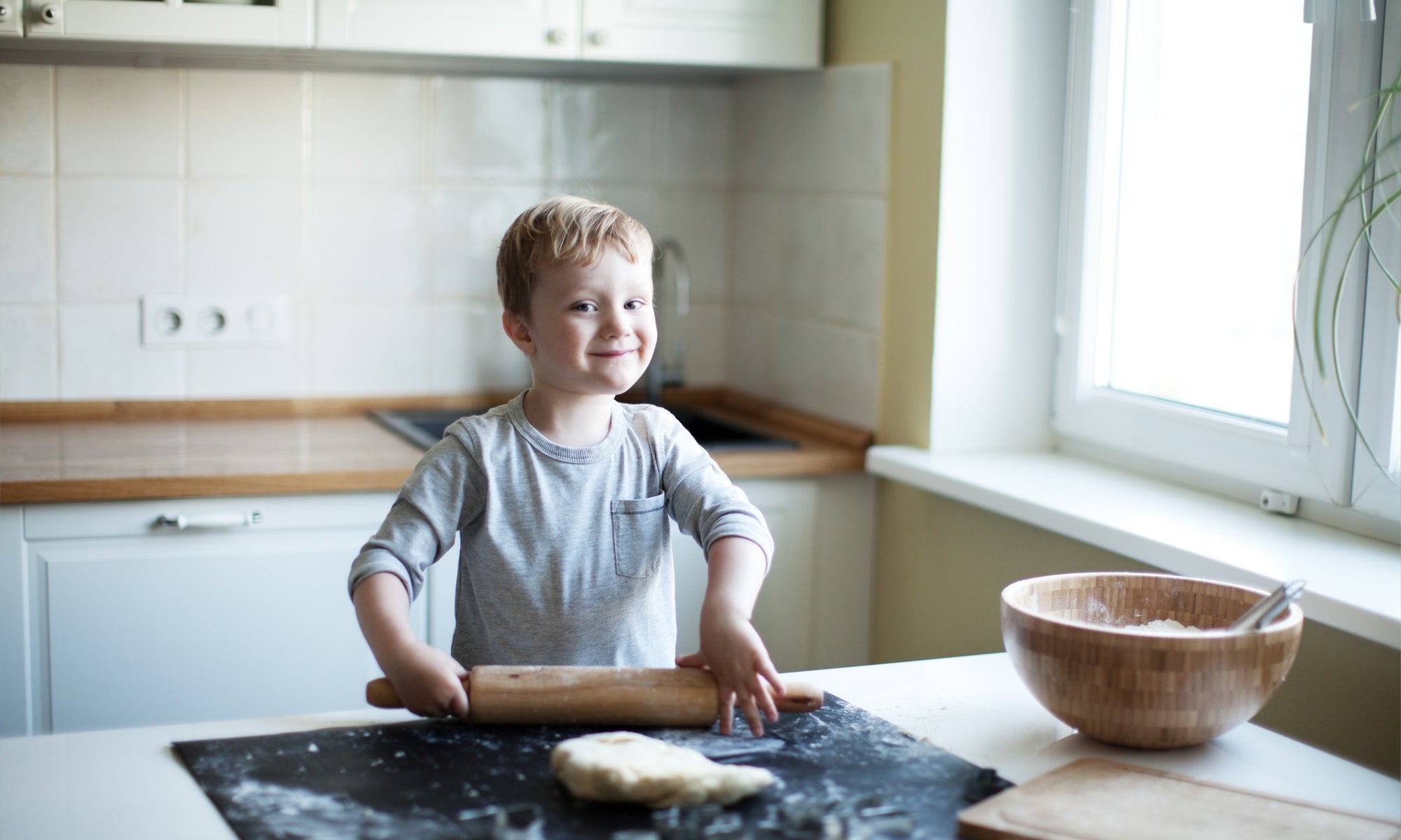 A child is making wheat chappati in the kitchen