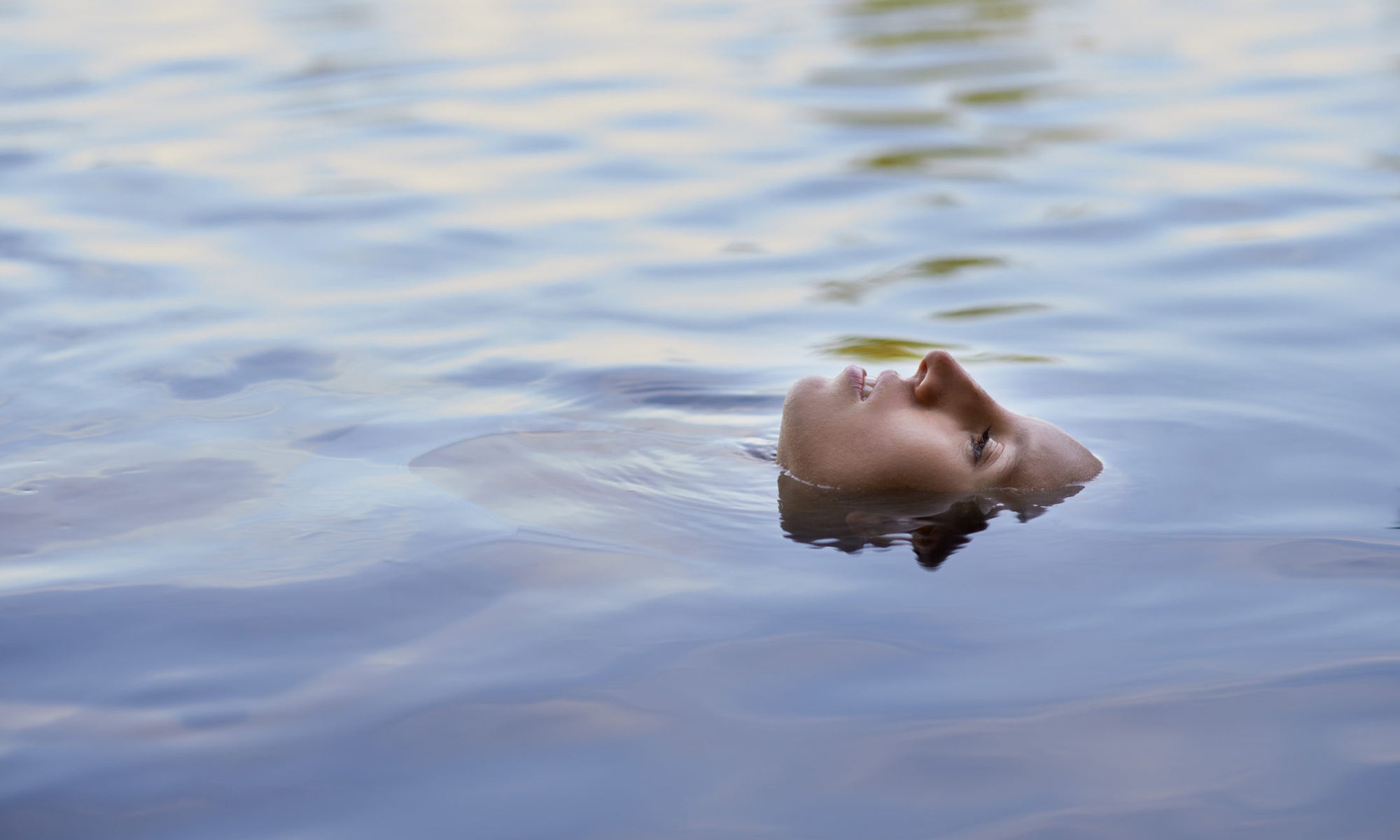 women float in lake with face-up