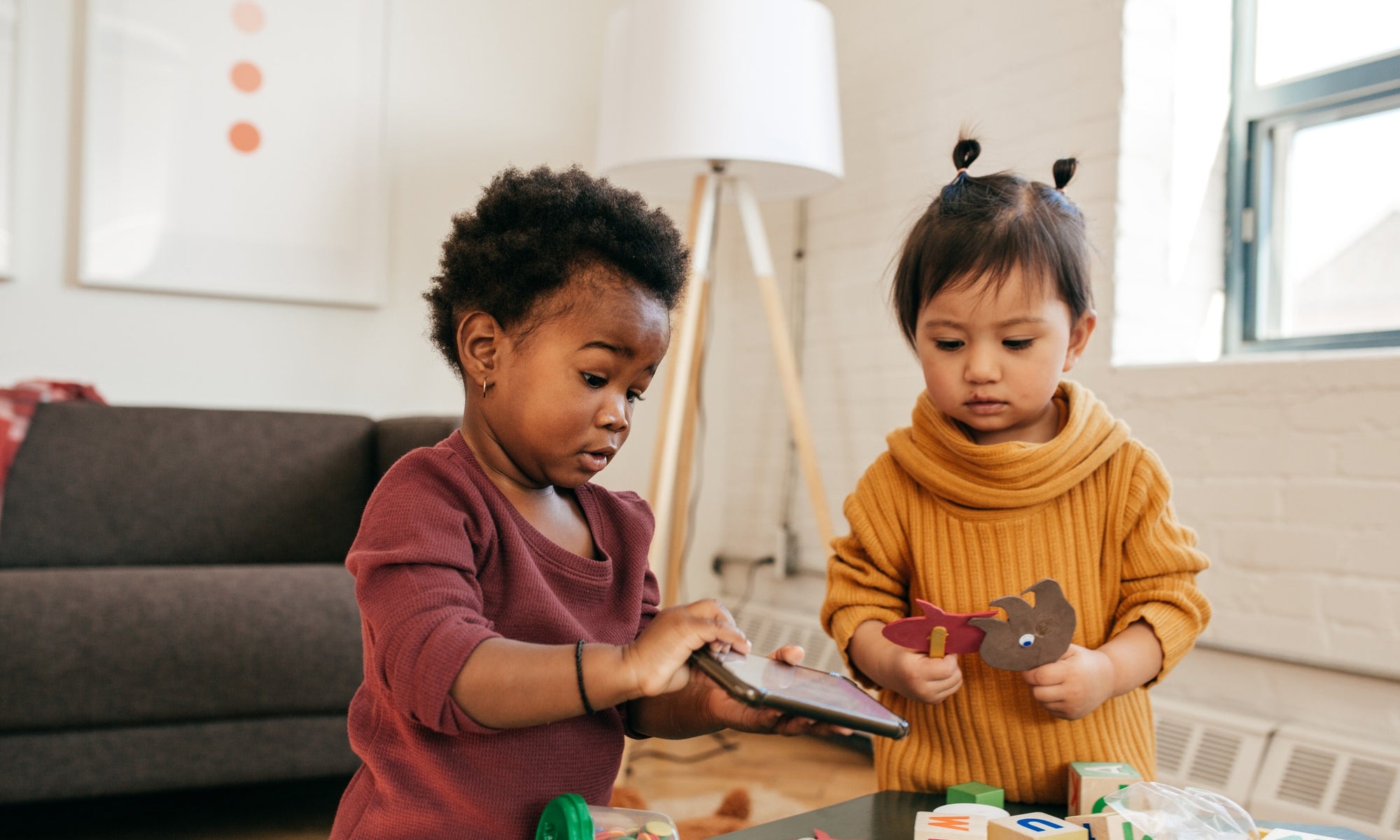 Two young sisters playing with toys on table