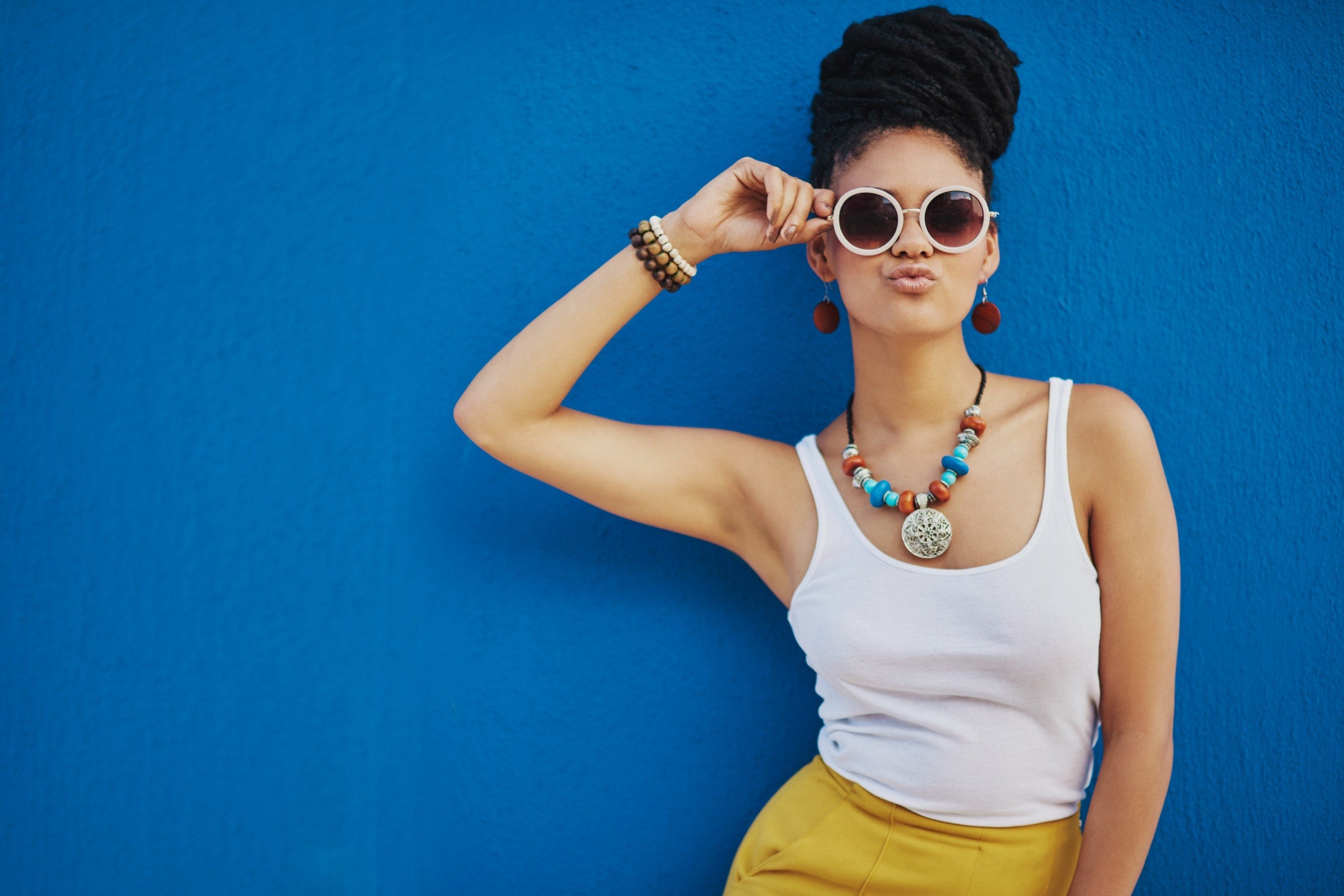 female in front of blue wall with kissing face