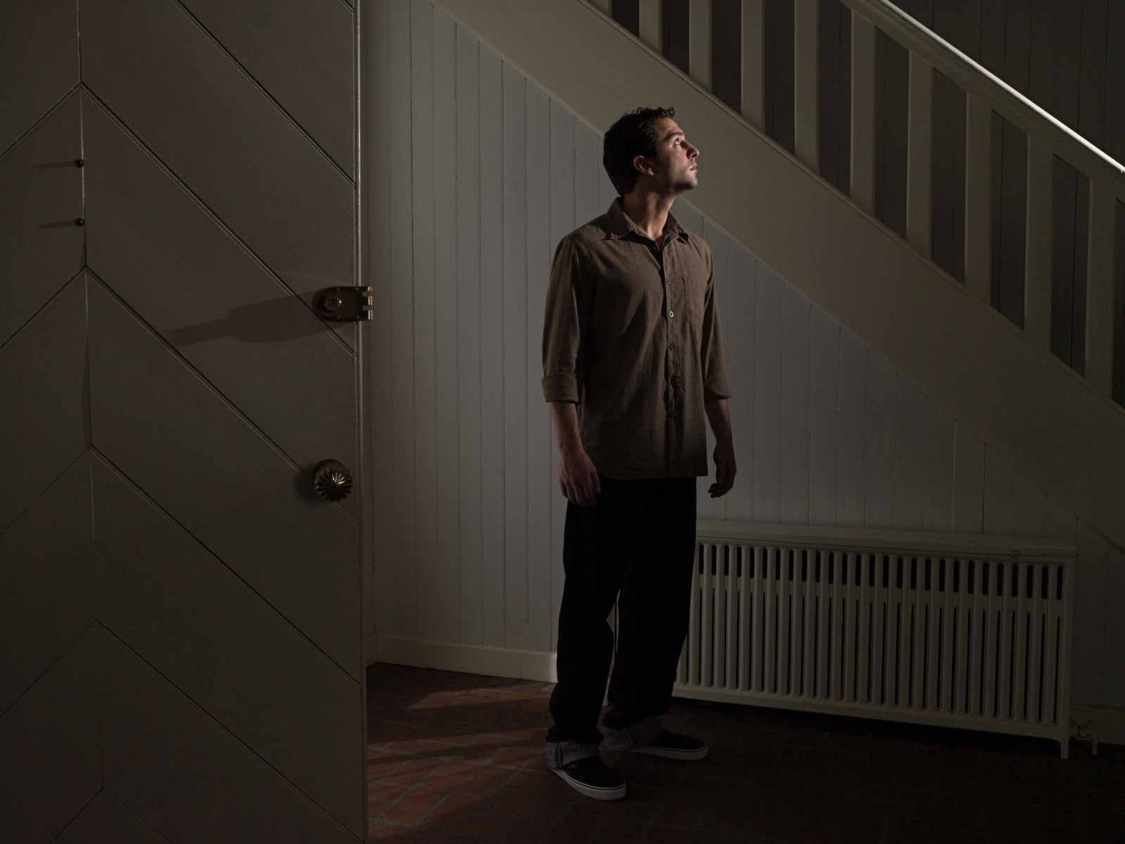 man standing beside staircase and looking up for something