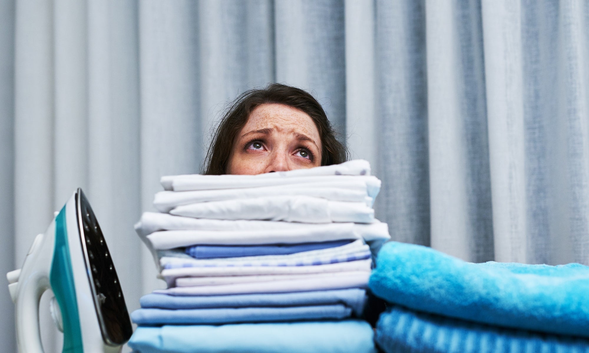 exhausted lady after ironing a pile of clothes