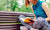 Young woman sitting on a bench in the park and reading book