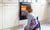 Young boy sitting in front of oven, looking through glass