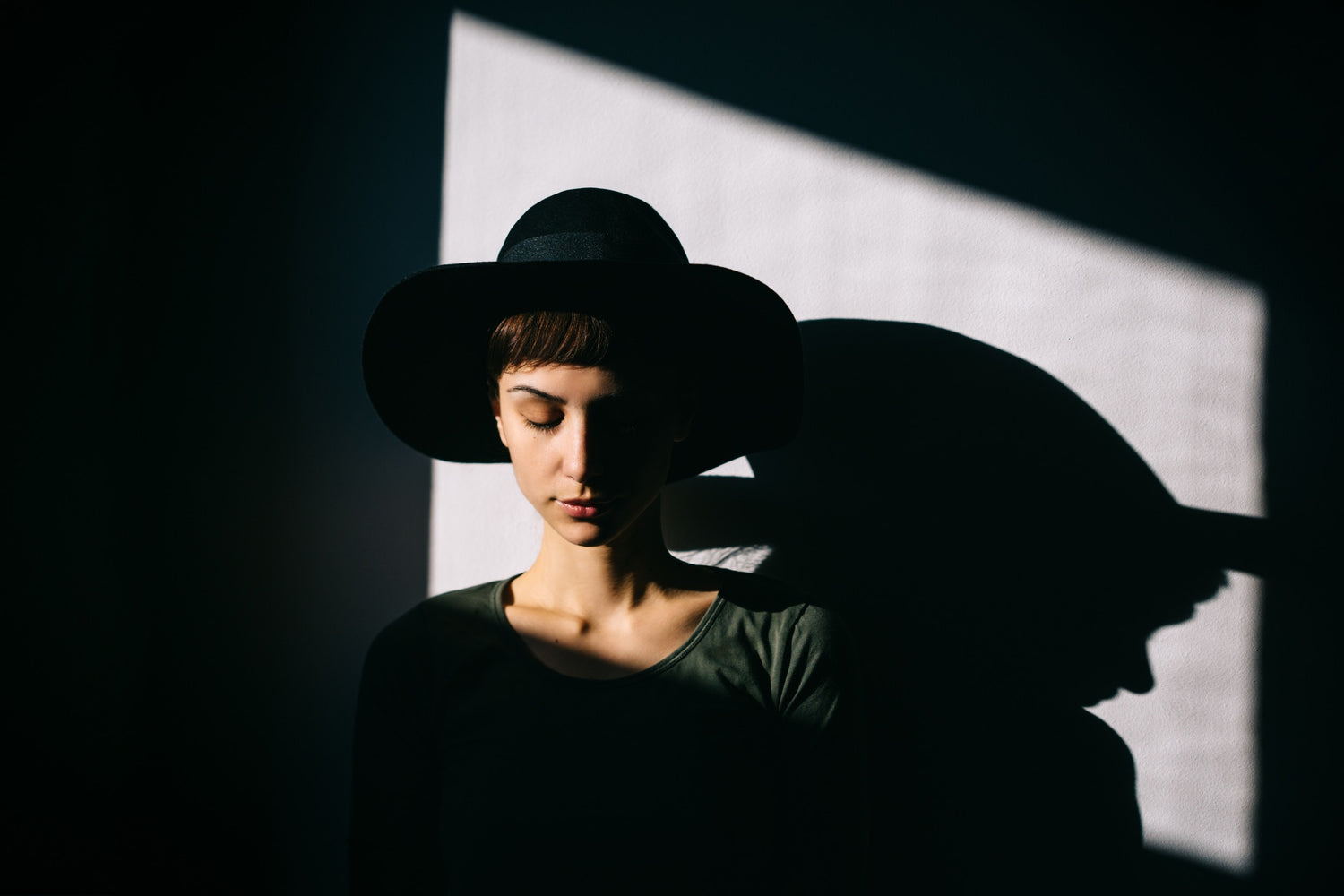 woman wearing a black hat looking down at the ground