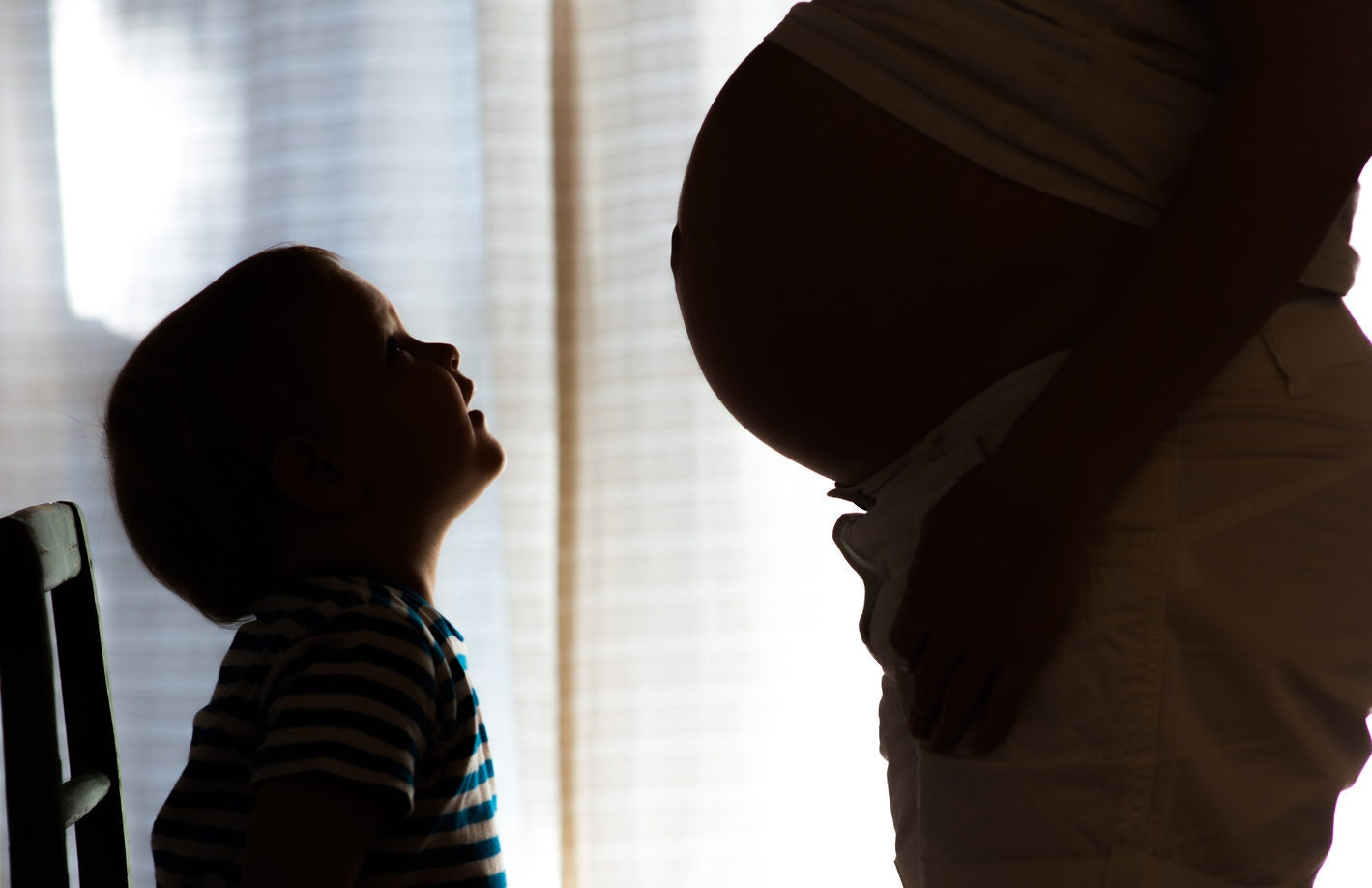 Little kid observing pregnant mummy big belly