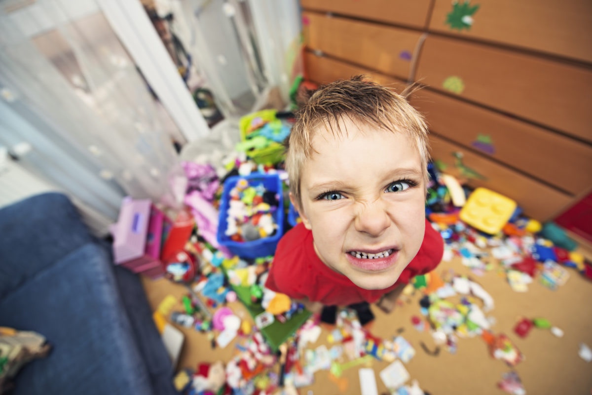 A boy seeing angrily with all toys dismantle