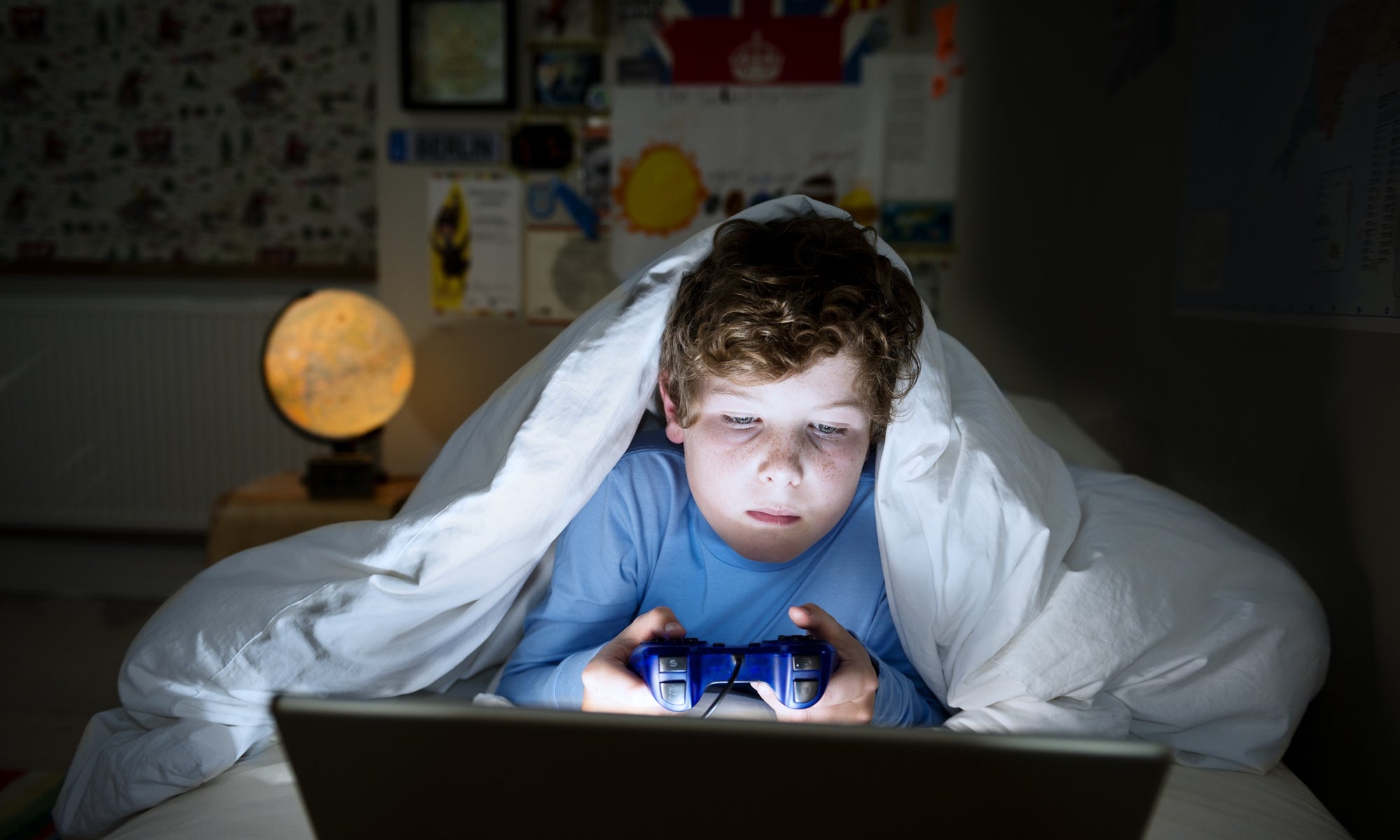 young boy playing video games late at night