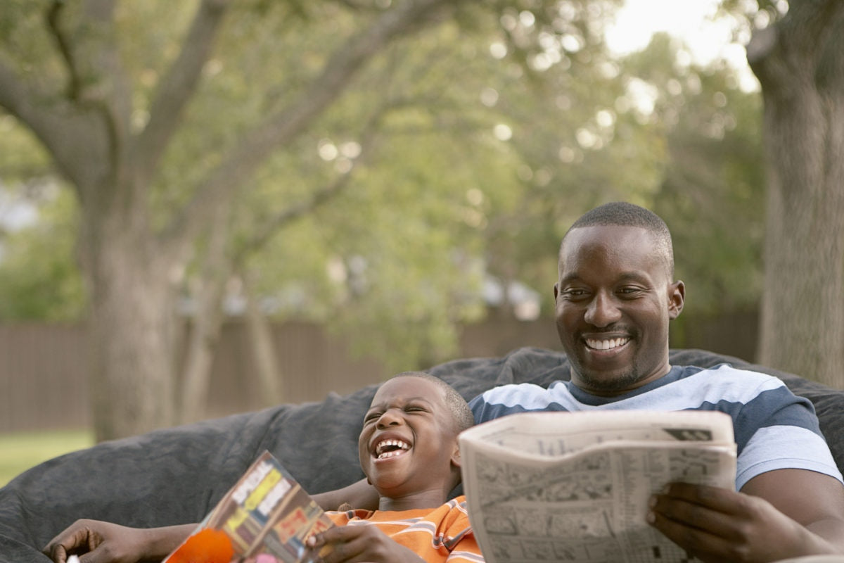 Happy father and son reading in the garden