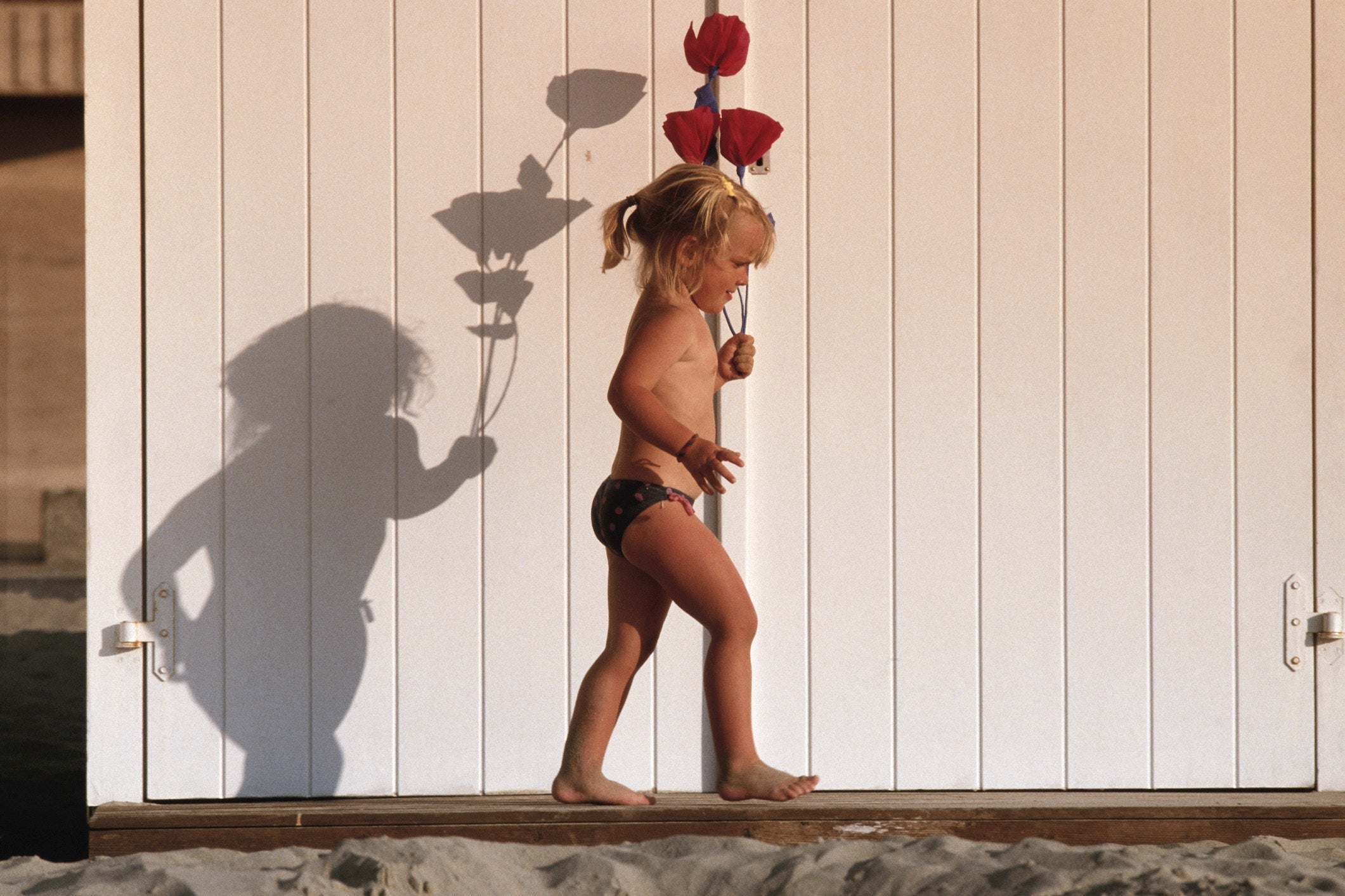 Girl walking with flowers outdoors, side view