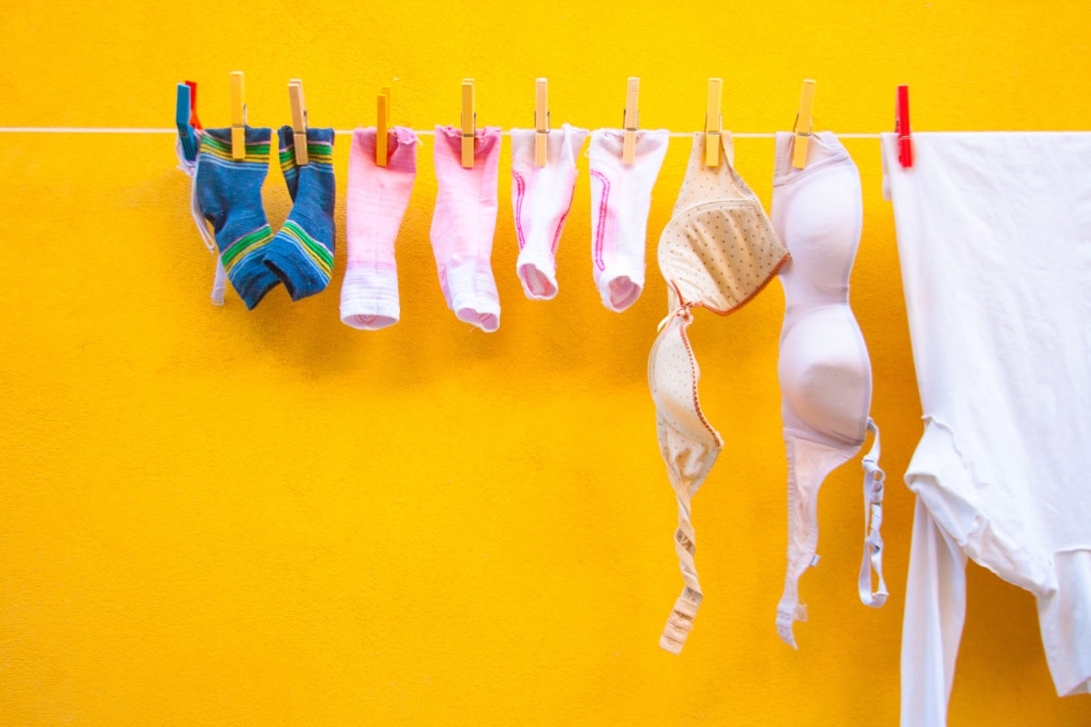 laundry drying on clothes line against a orange wall 