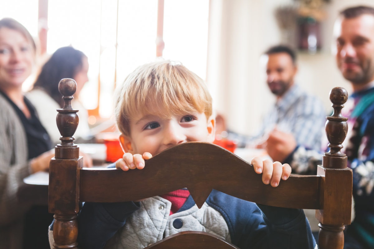 Parents teaching table manners to preschoolers