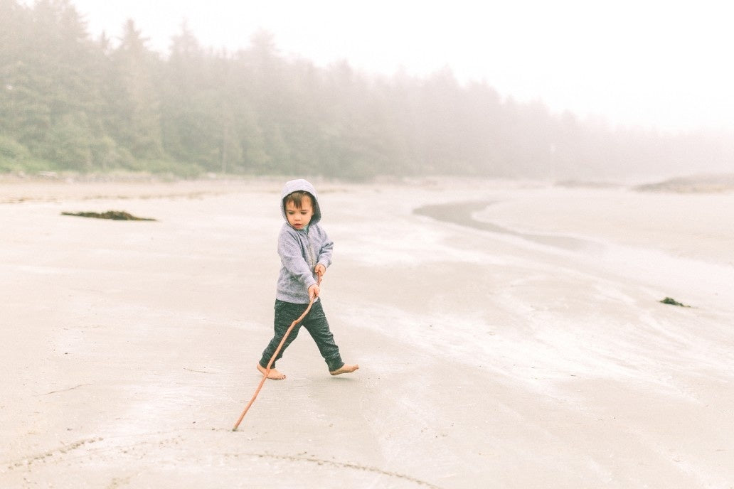 kid drawing a circle at the beach