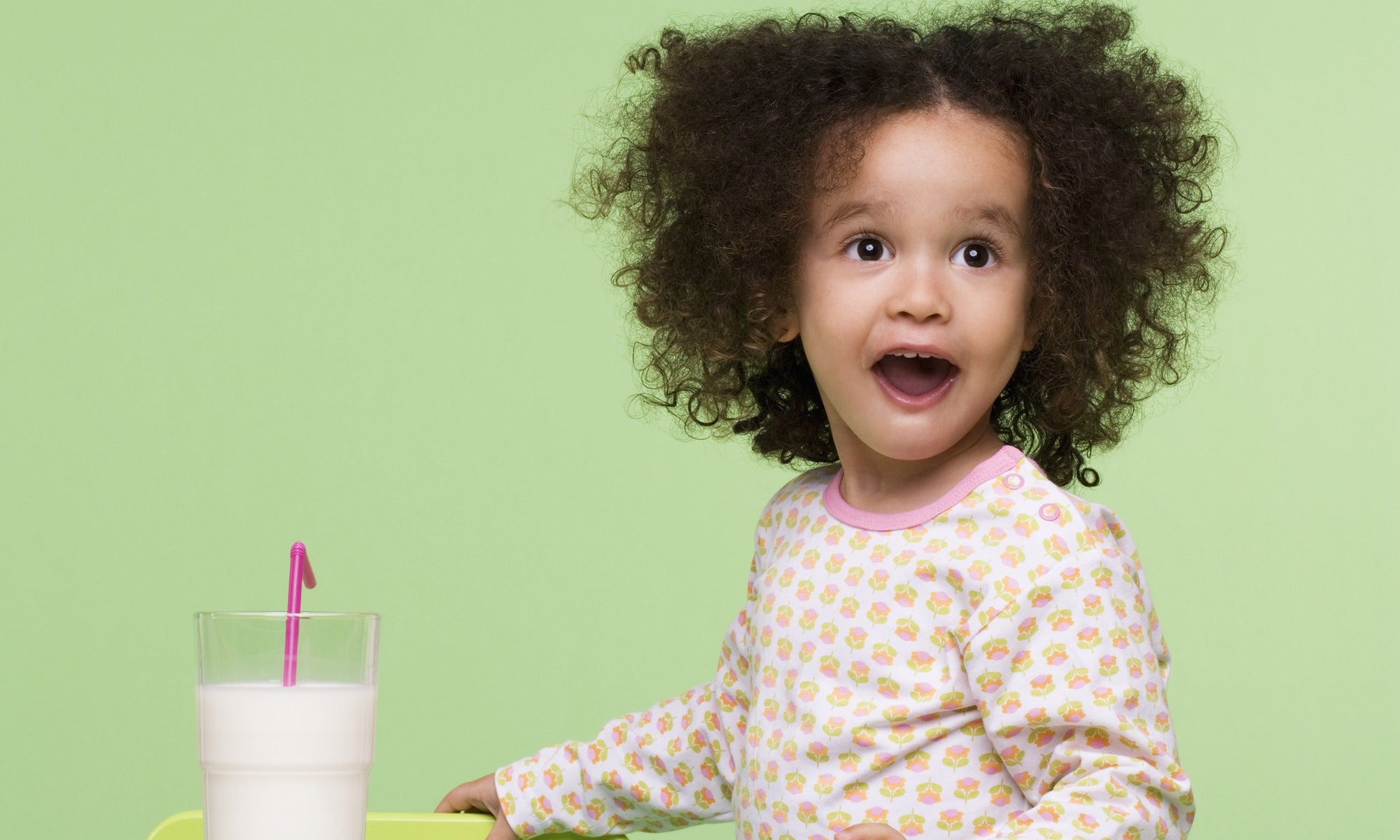 surprised little girl looking at a glass of milk