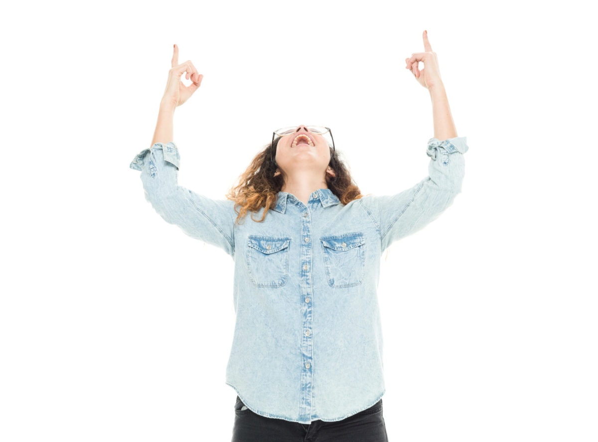 Girl is feeling happy by showing both hands up towards sky