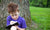 little boy sitting under the tree and writing in a book