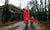 Mother with daughter wearing rain coat and rubber boots walking in a rainy weather 