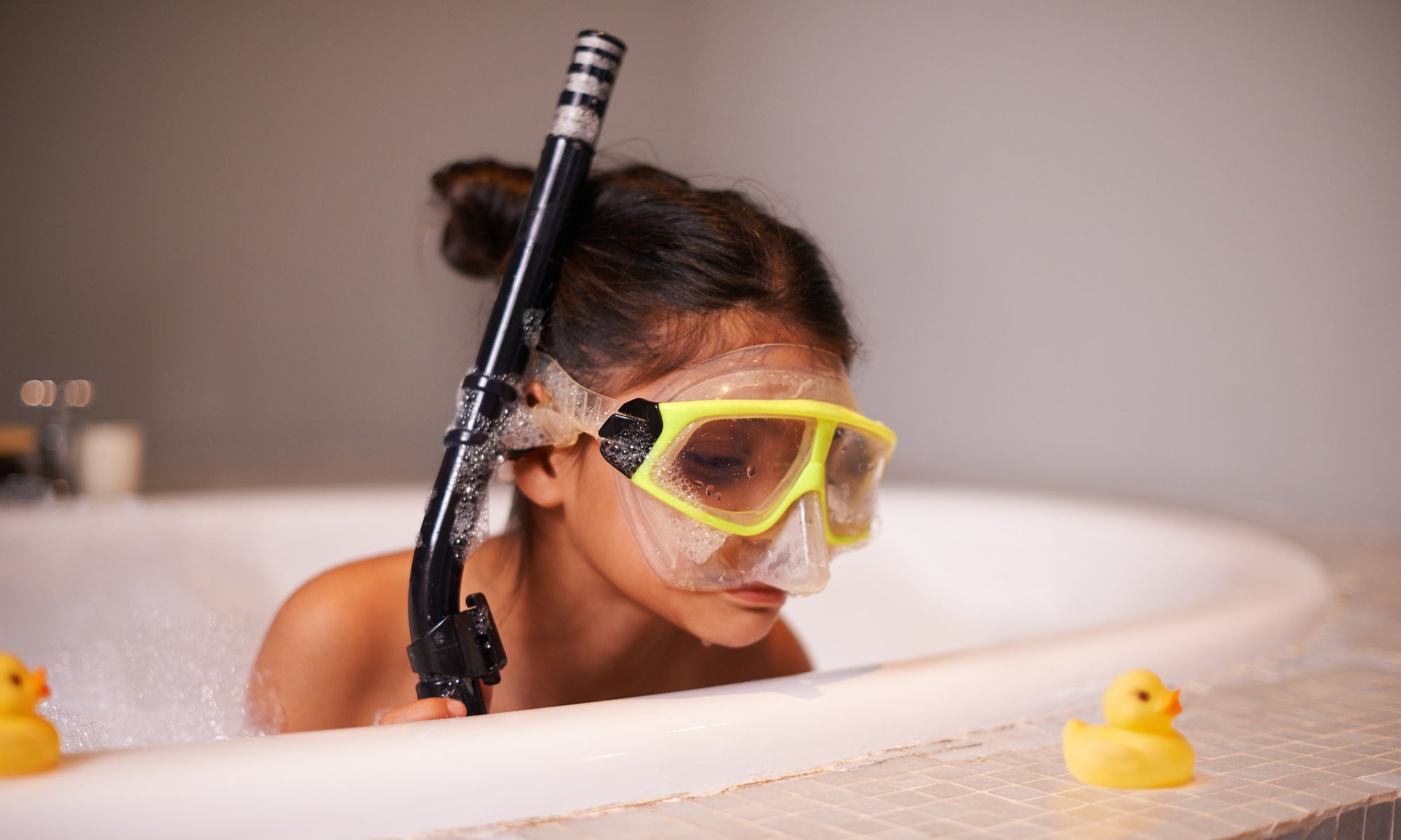 kid on a tub with breathing tube and swim googles