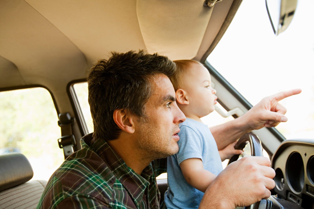 Father navigating on a car along with his baby