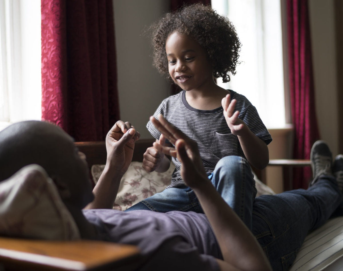 little girl sitting on father's stomach and learning maths