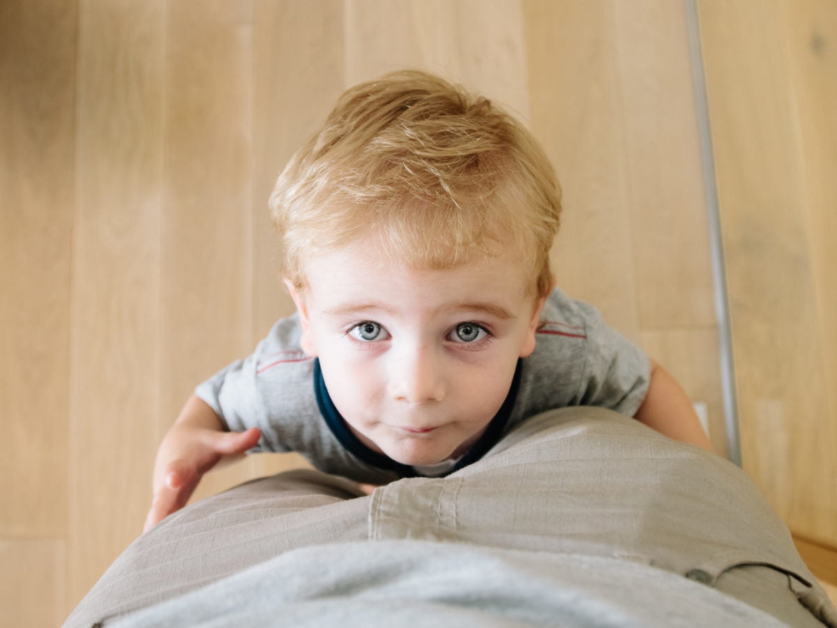 little boy holding his father legs and lookin up