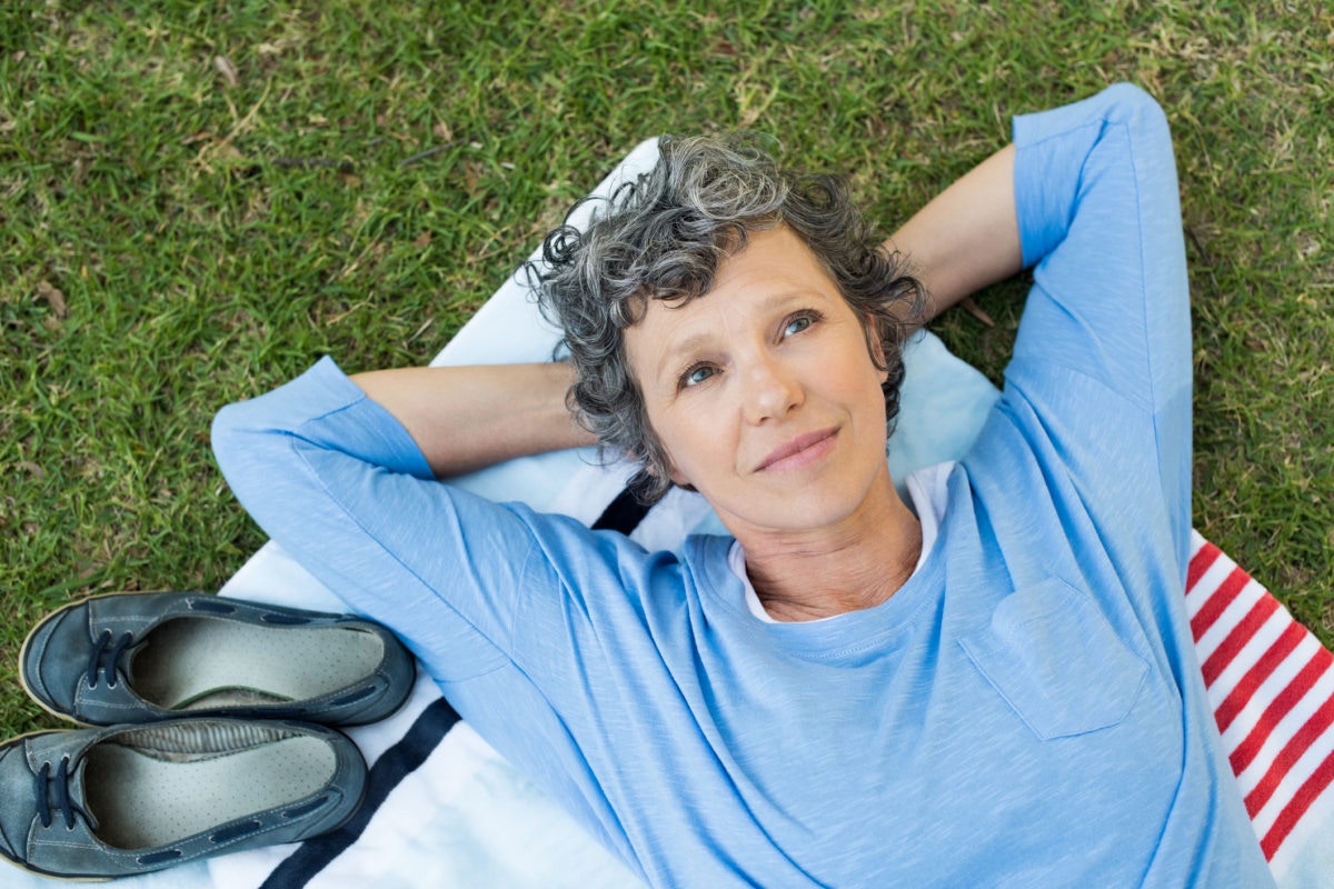 mature woman lying in the park looking at the sky