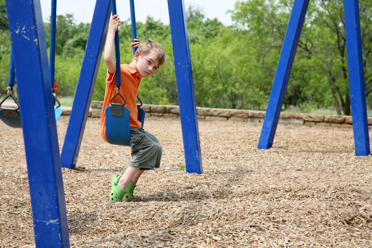 Sad Looking Boy Sitting On A Swing