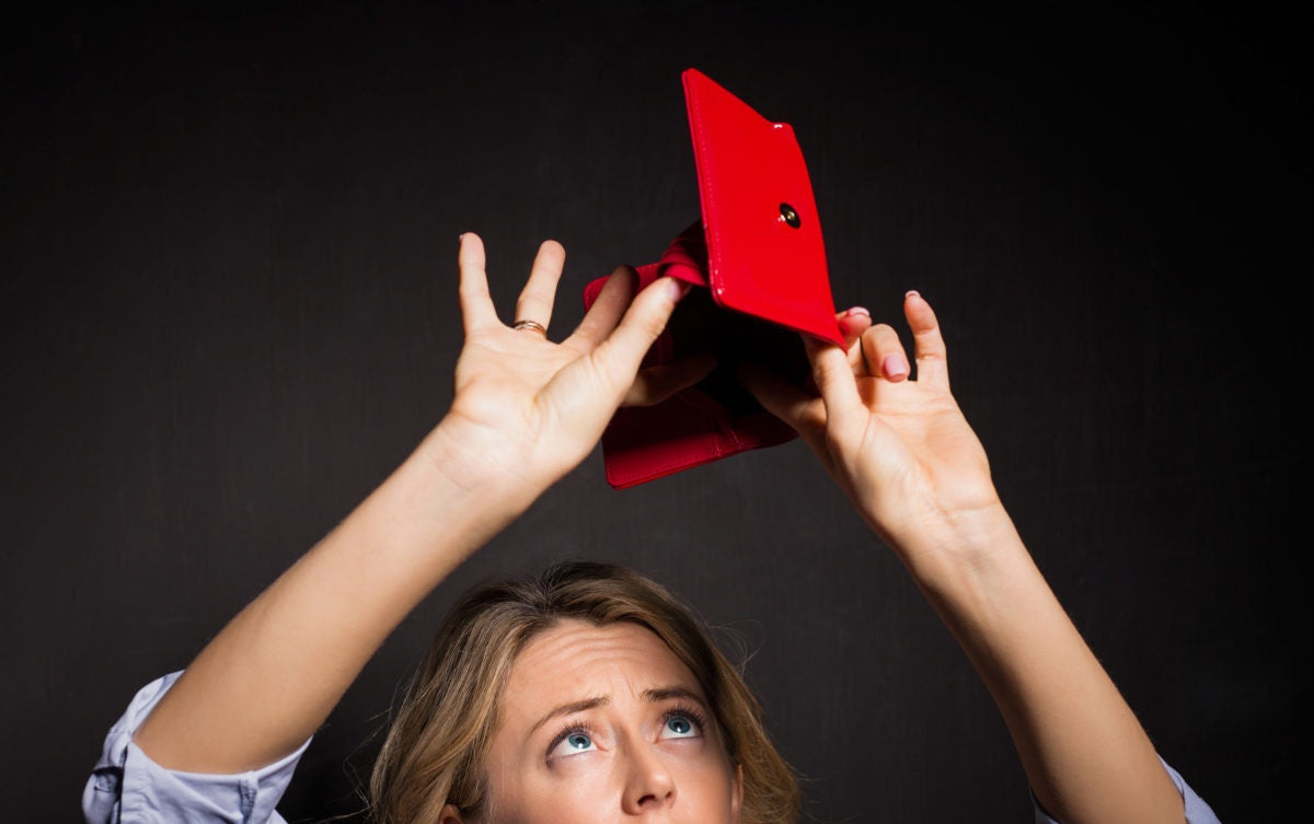 A young woman looking in an empty wallet