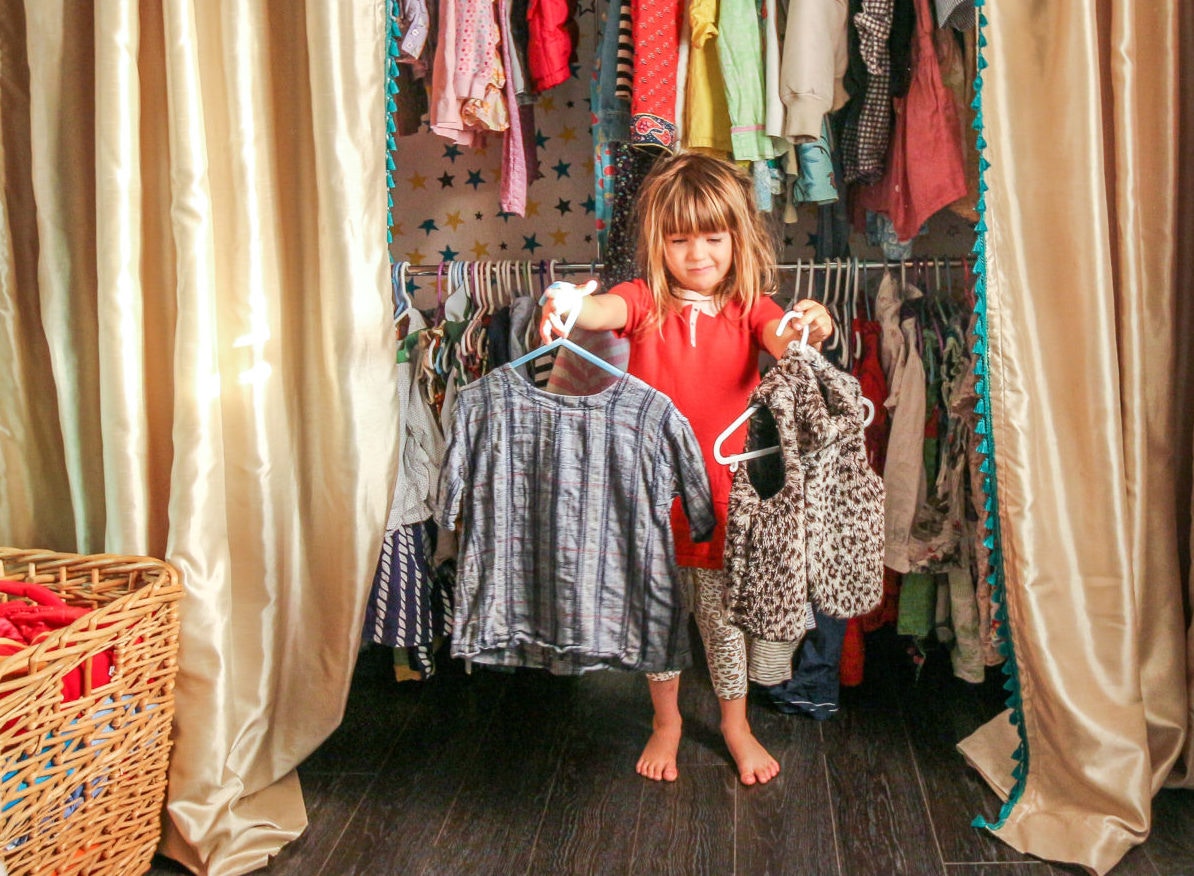 A child selecting dress from the closet