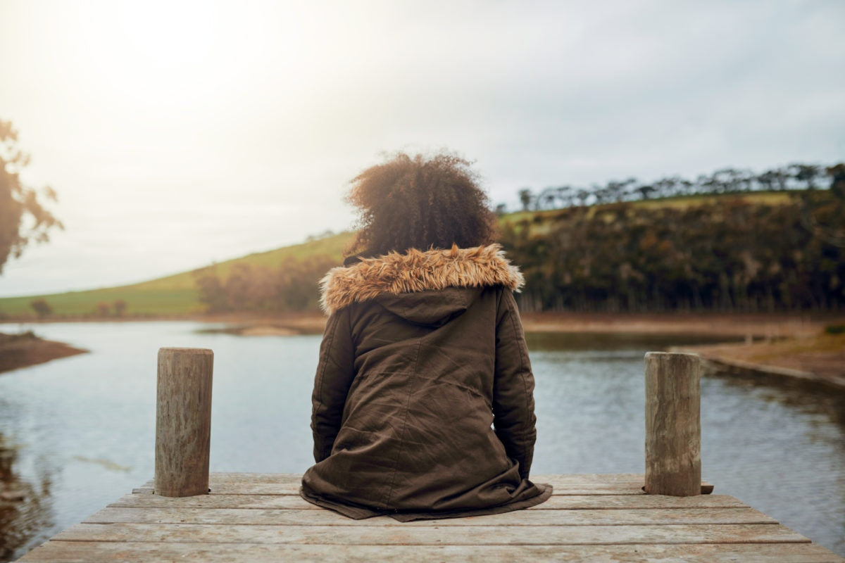 A child is sitting near river side