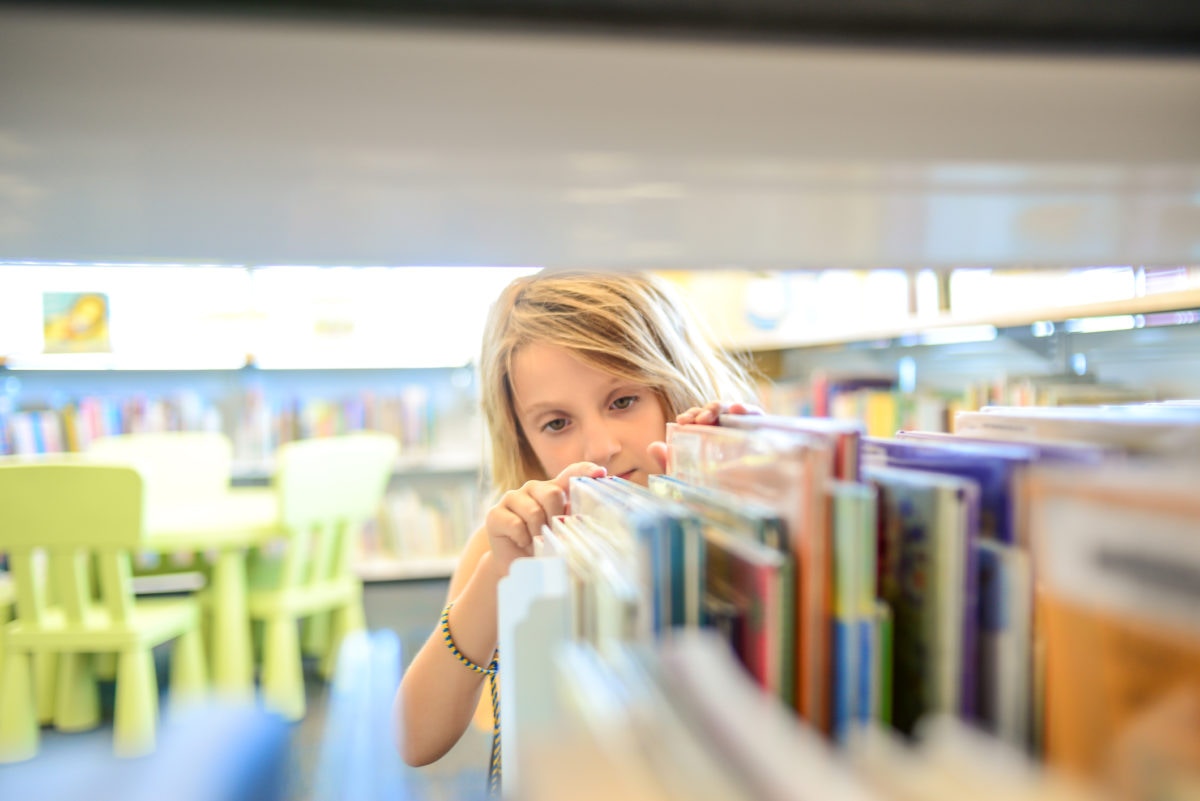 young girl looking at books