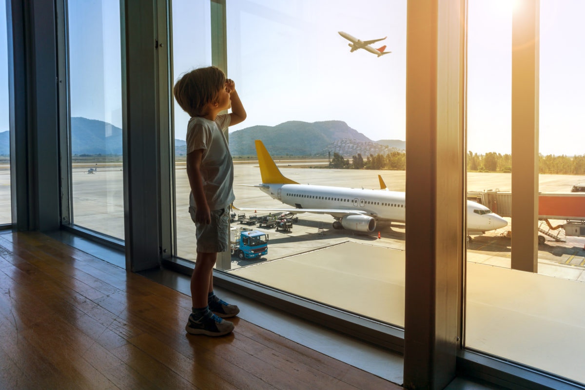 A boy watching flying aeroplane