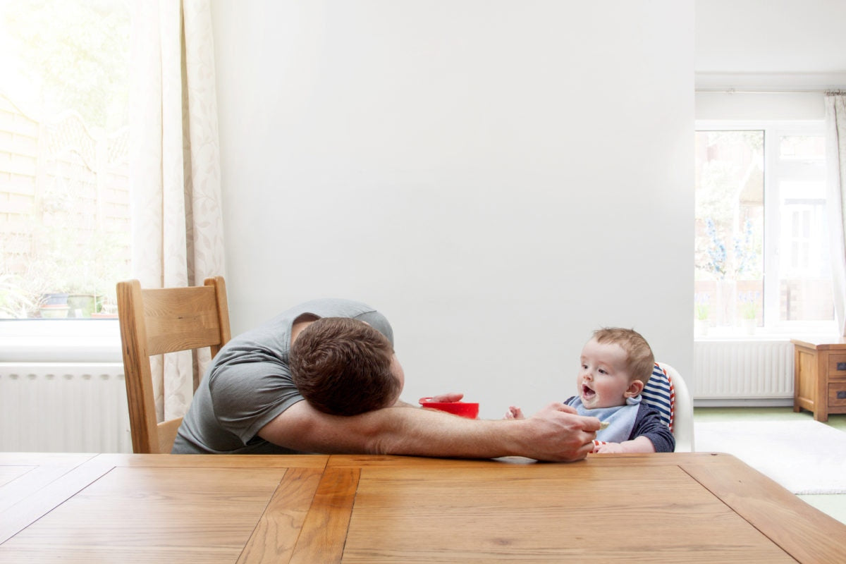 A father feeding food to a kid