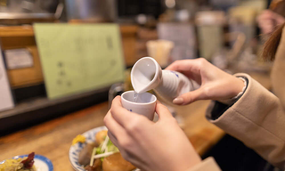 pouring sake into a cup