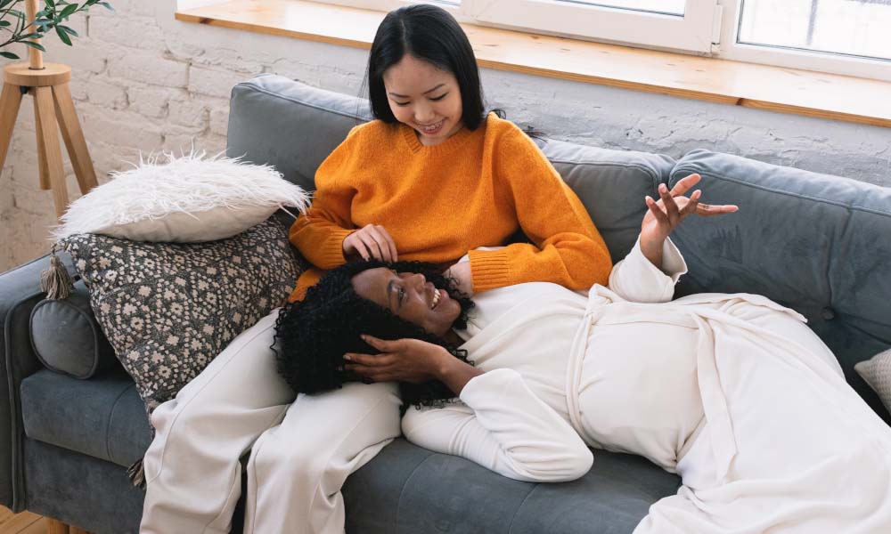 two women sitting on couch